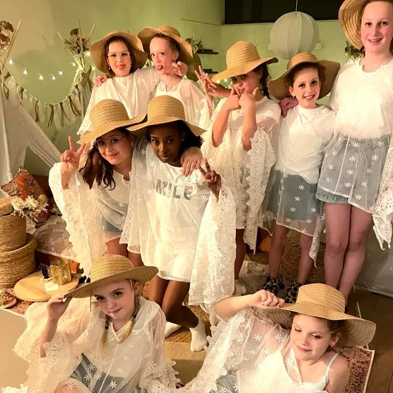 Grote groep meiden met strohoeden bij de boho tipi’s