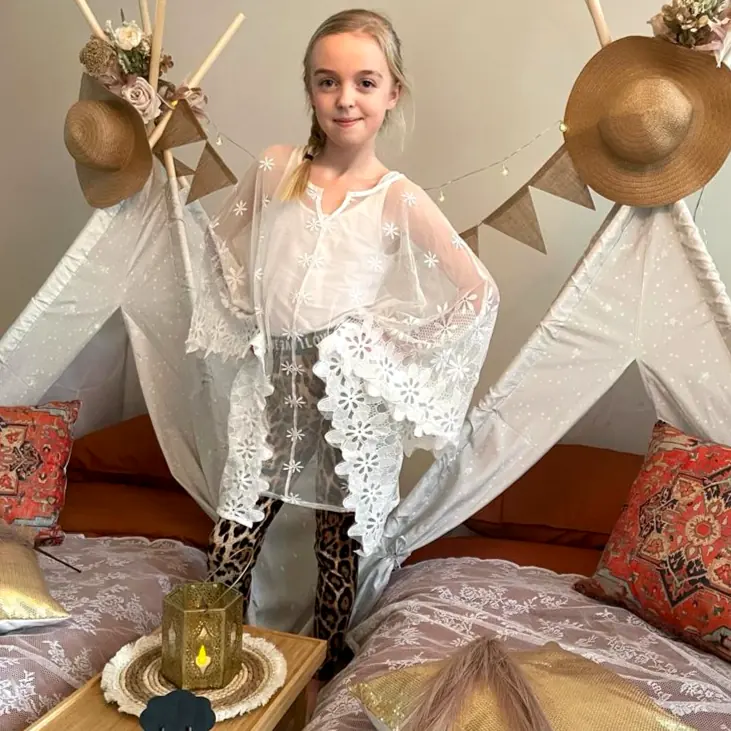 Meisje in een kanten boho kimono voor haar tipi