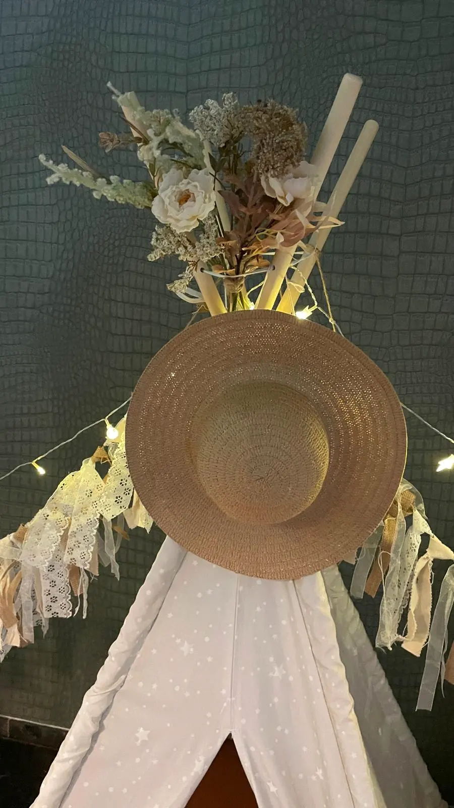 Strohoed en droogbloemen bovenop een boho tipi
