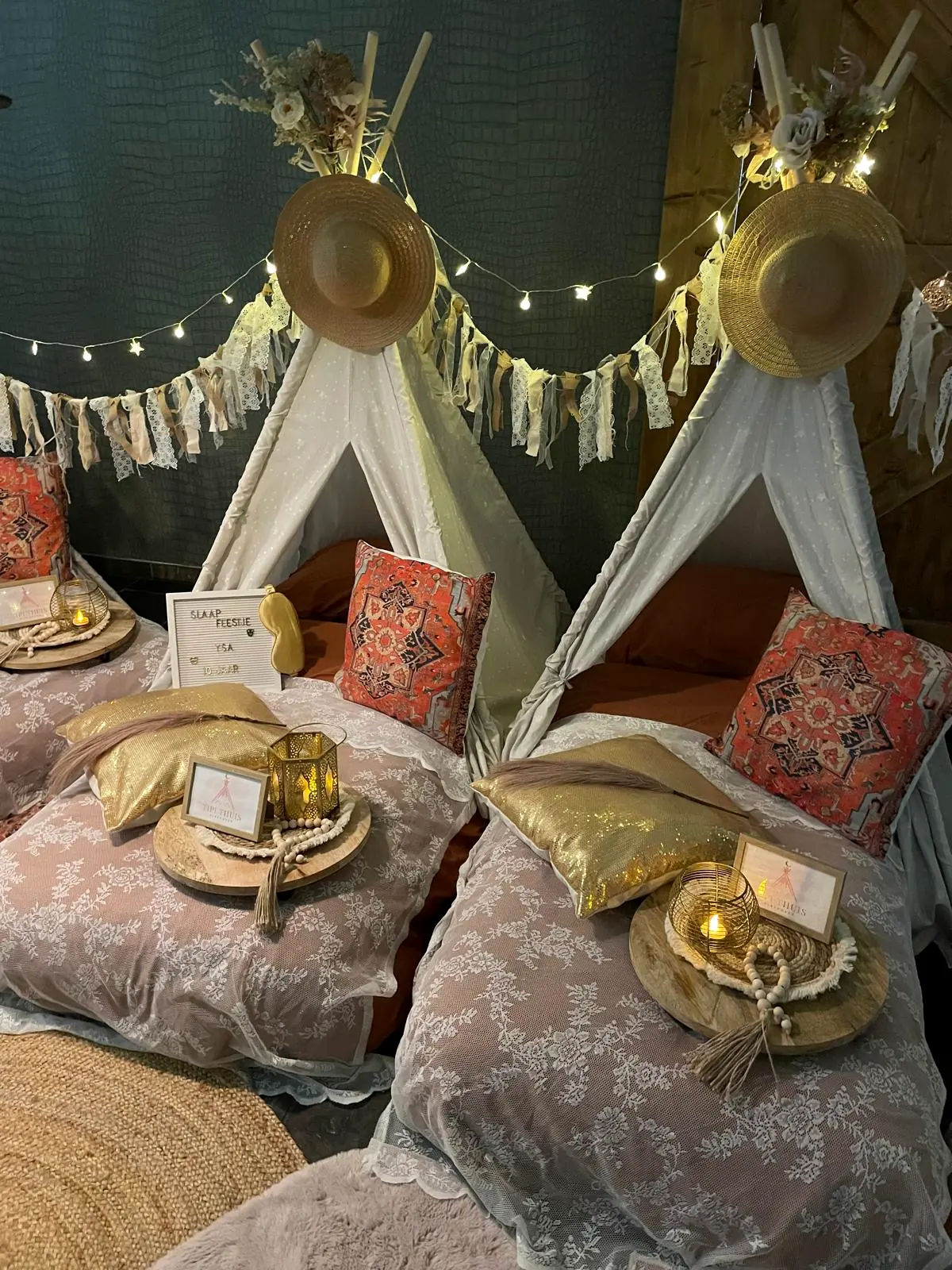 Boho-chic slaapfeestje: witte tipi’s met strohoeden, franjes en goudkleurige kussens