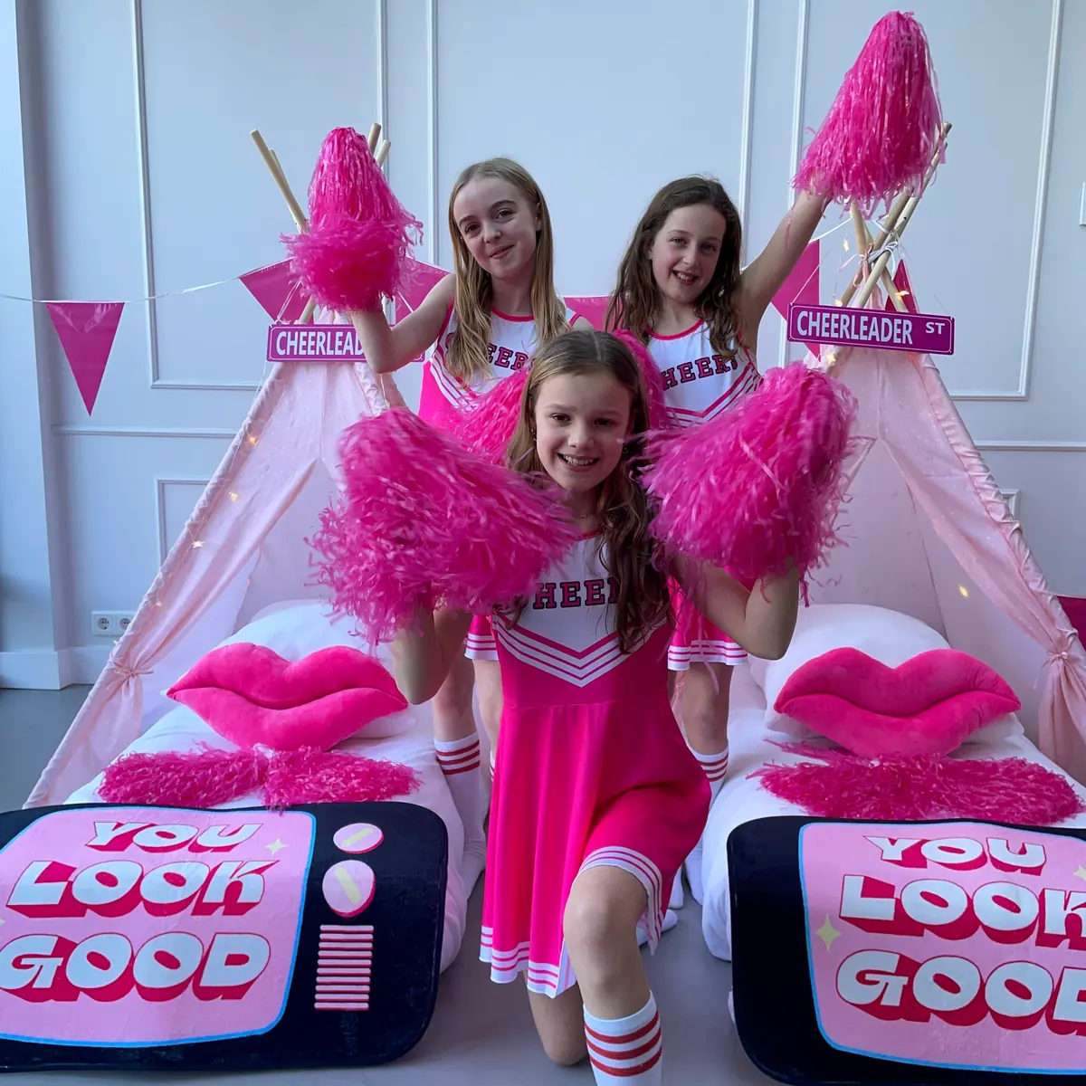 Cheerleaders met roze pompons bij de tipi’s met You Look Good kussens