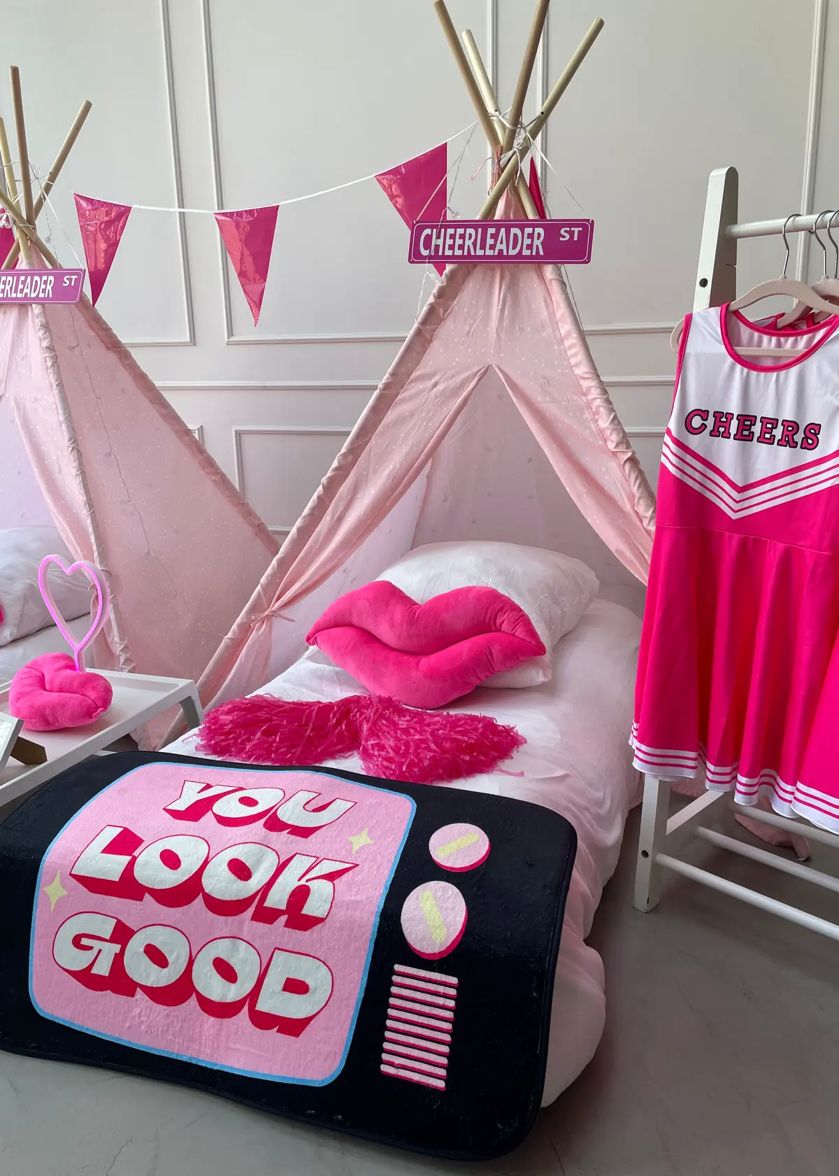 Cheerleader tipi met kledingrek vol cheerjurkjes en een You Look Good kussen
