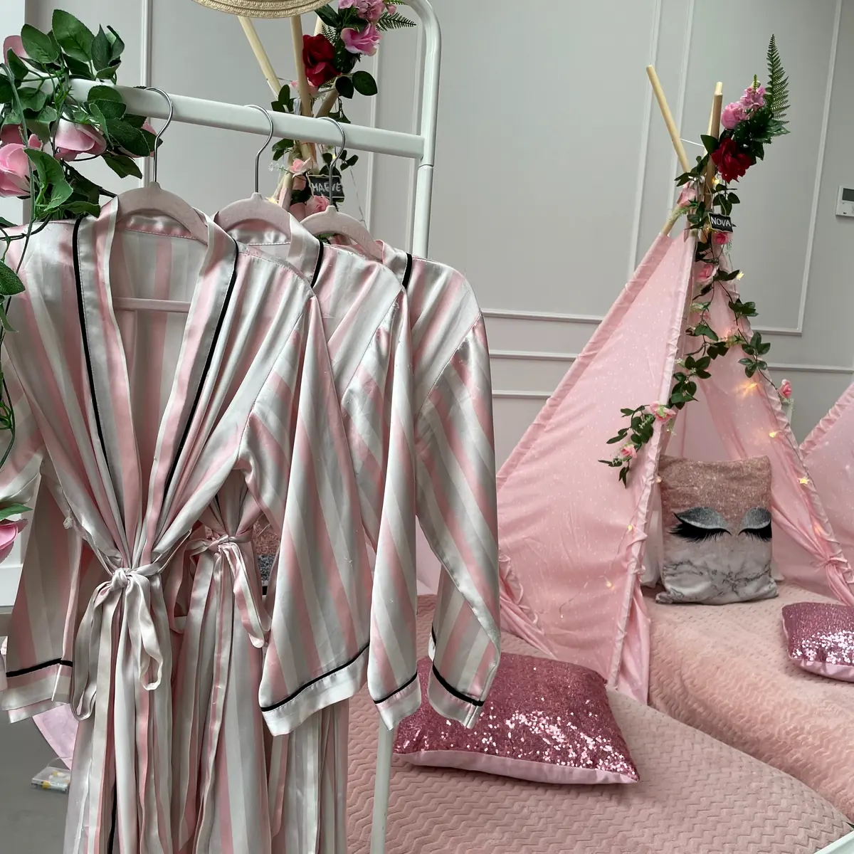 Satijnen kimono’s aan het kledingrek naast de roze girlpower tipi’s