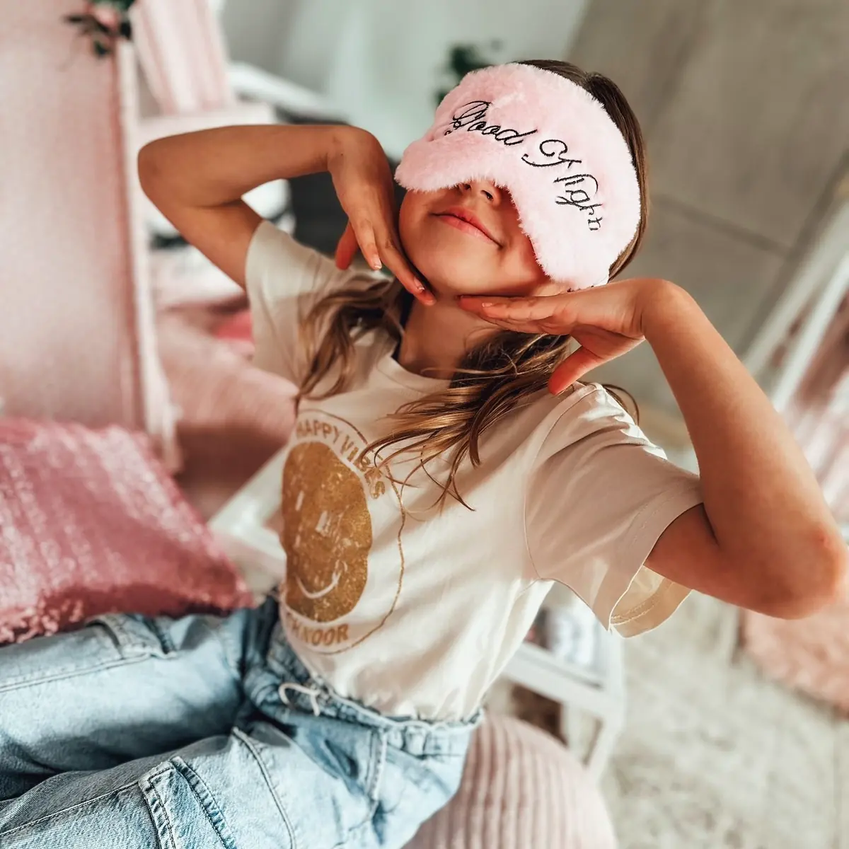 Meisje met slaapmasker poseert in haar roze tipi