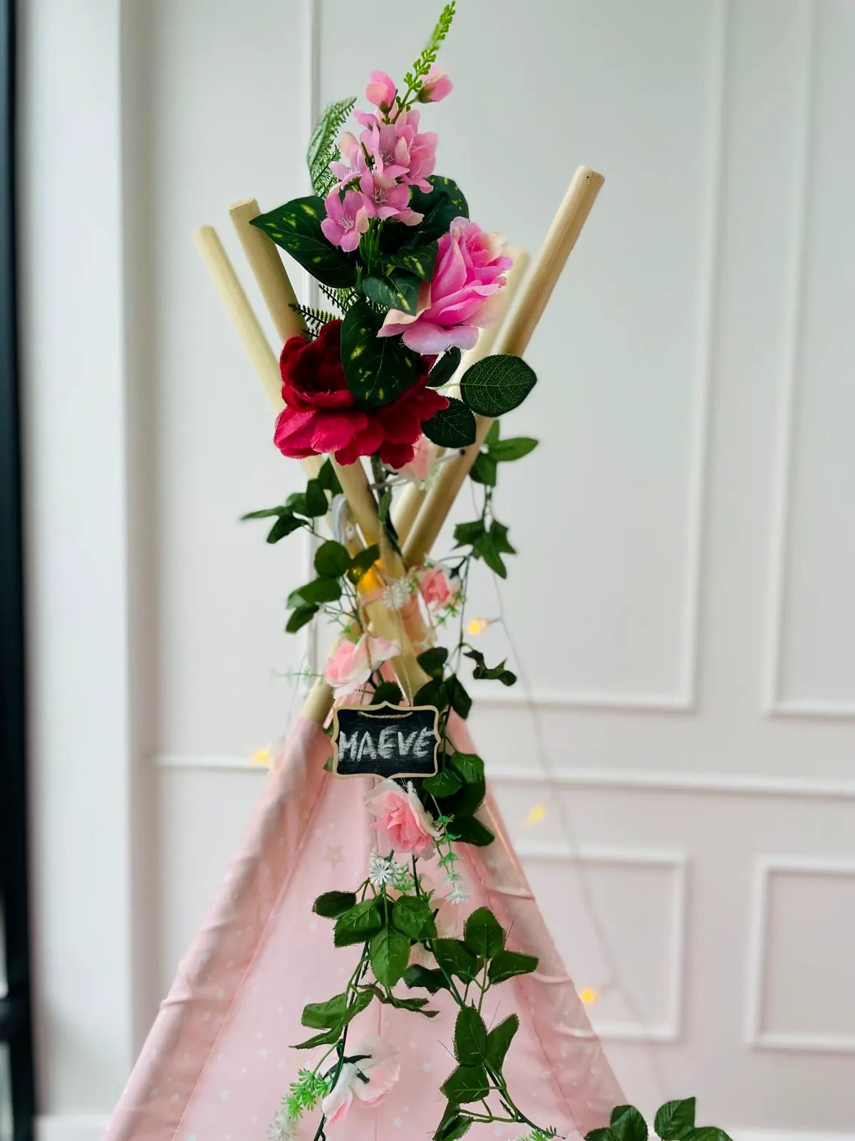 Top van een roze tipi met rozen en een naambordje