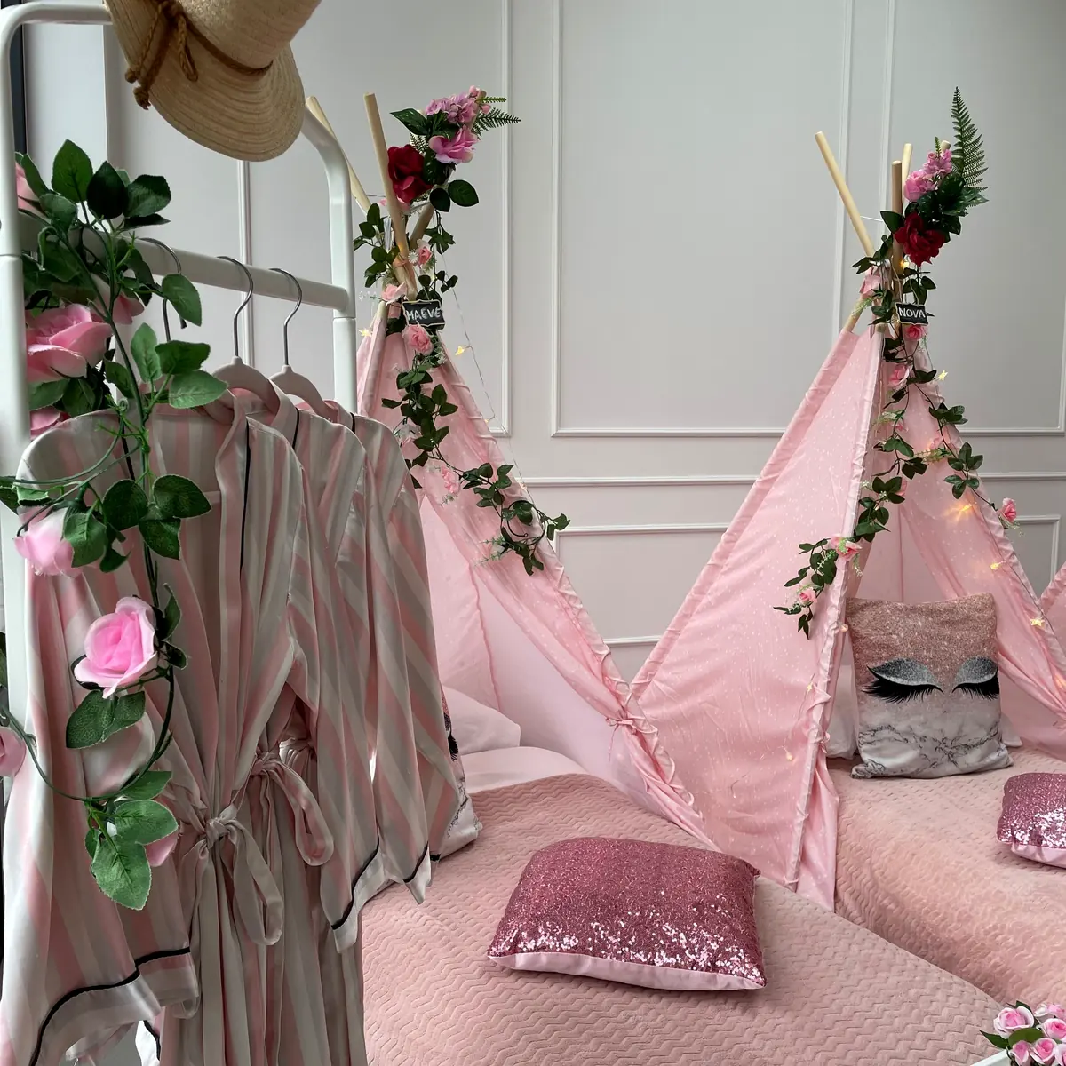 Roze tipi’s met klimop en rozen, kimono’s aan het rek