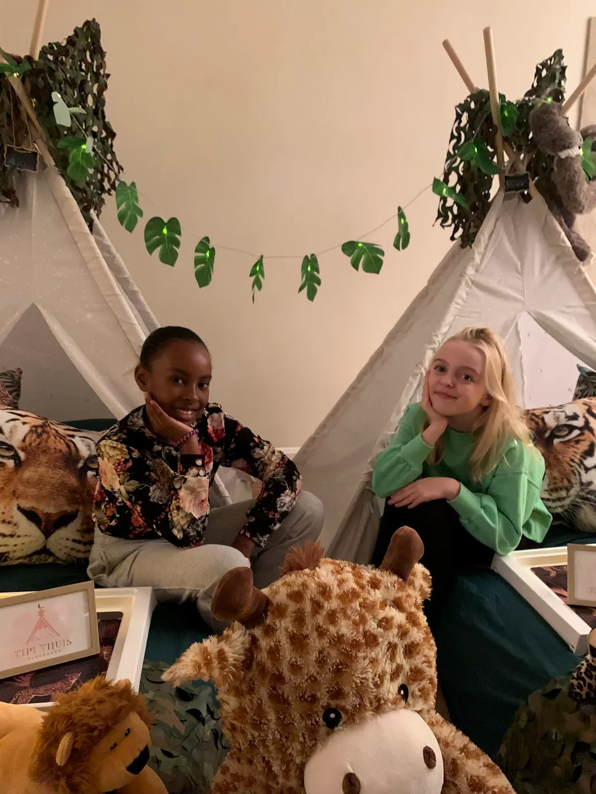 Kinderen zitten samen in de jungle tipi’s
