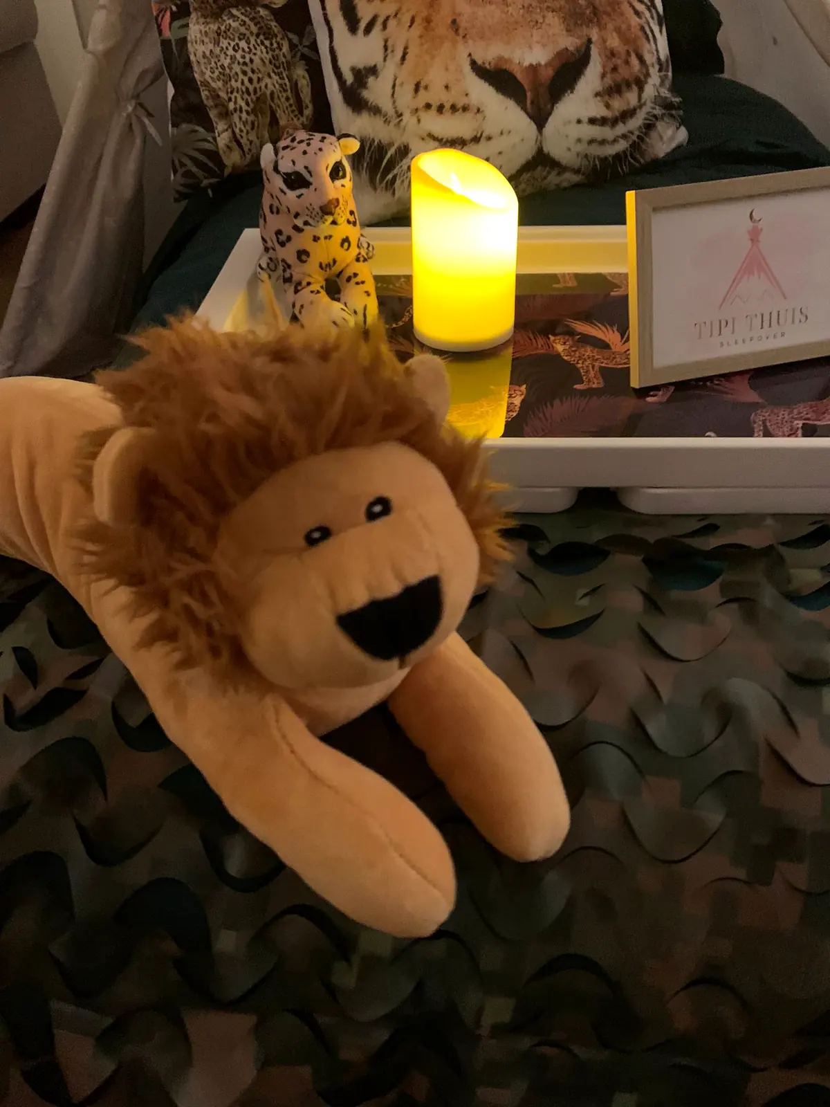 Knuffelleeuw bij kaarslicht in de jungle tipi