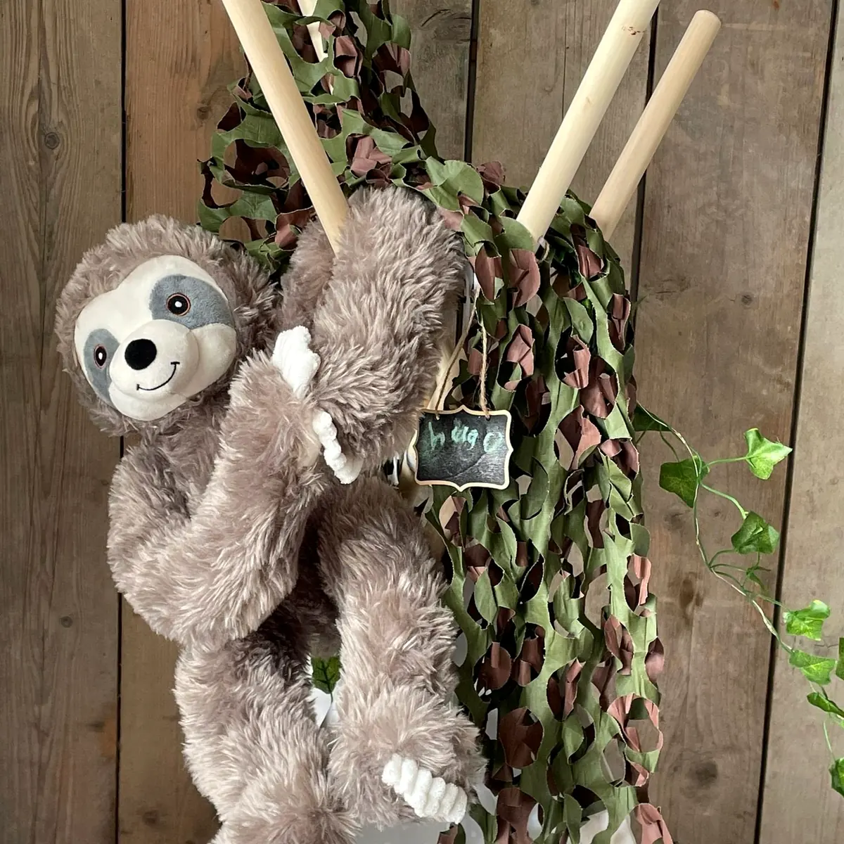 Knuffelluiaard hangt aan de top van een jungle tipi