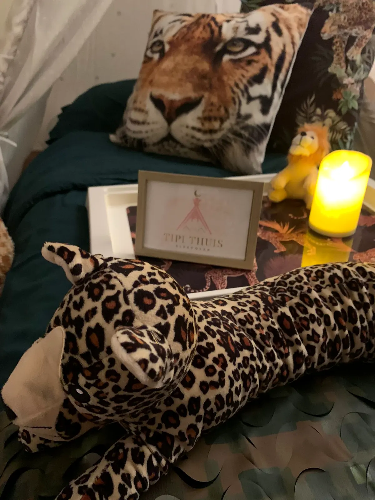 Tijgerkussen en knuffelluipaard op het bed in de jungle tipi