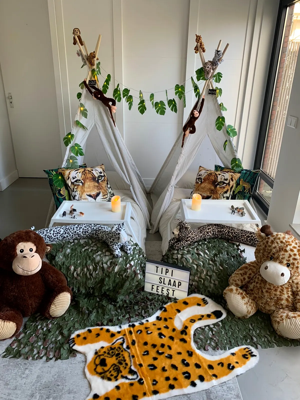 Twee jungle tipi’s met slingers van bladeren, knuffelapen en een luipaardkleed