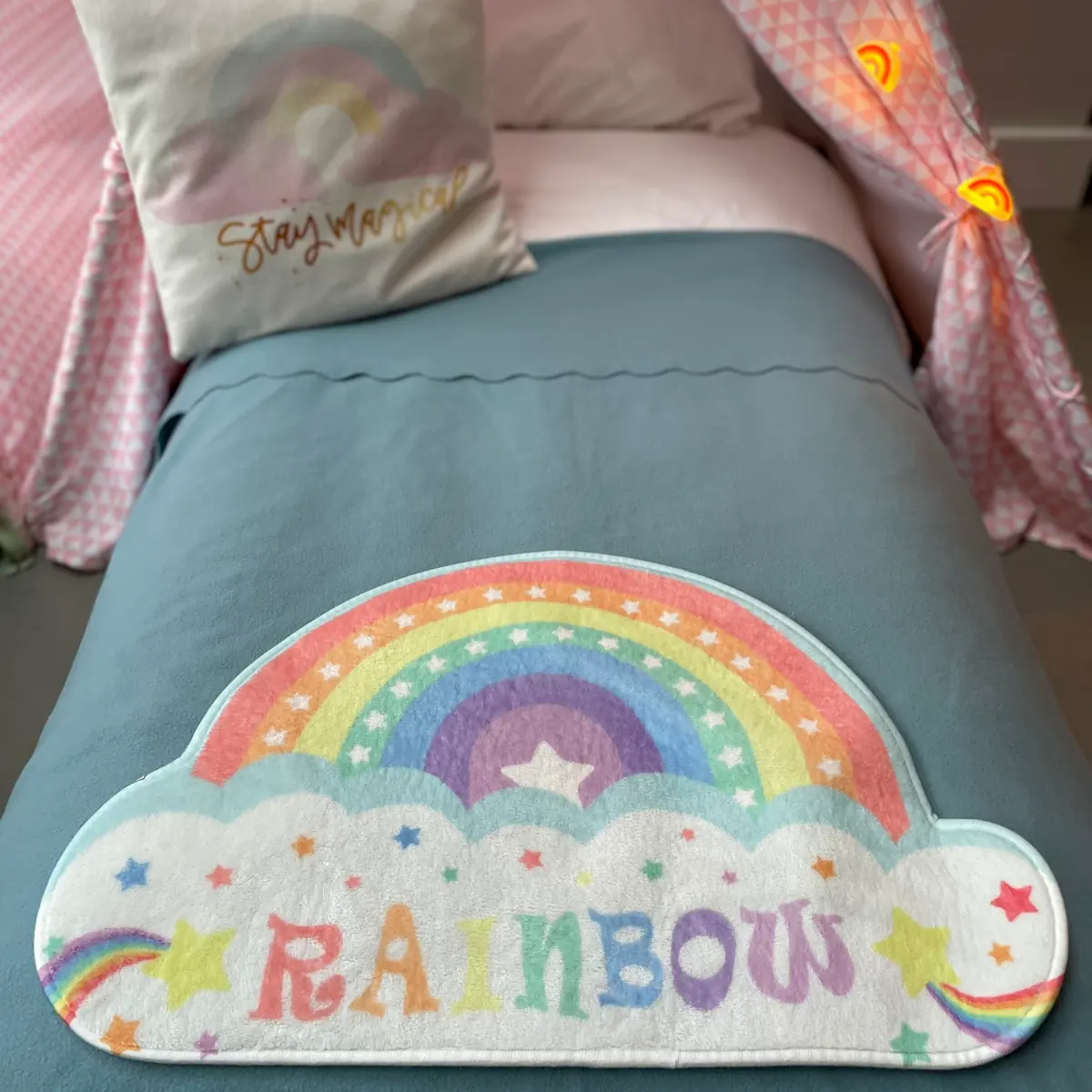 Regenboogkleed op het bed in een roze rainbow tipi
