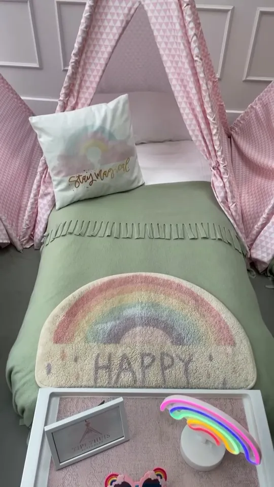 Rainbow slaapfeestje met een neonregenboog op het bedtafeltje